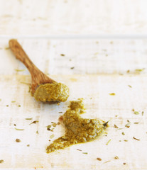 pesto sauce on a wooden table with spoon