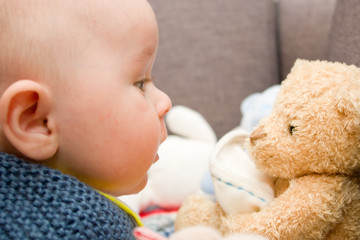 Three month old boy with Teddy Bear watching to each other