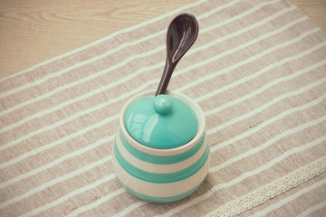 Green pastel porcelain jar and brown spoon in vintage style.