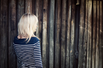 Fototapeta premium Young woman portrait infront of old wooden wall