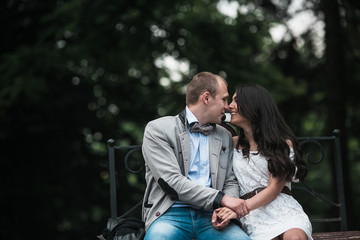 Young European couple cuddling on a park bench