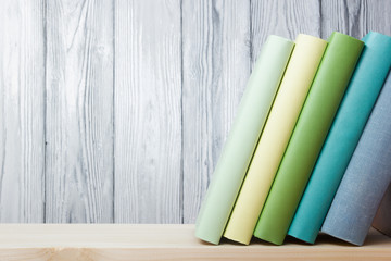 Stack of colorful books on wooden table. Back to school. Copy space