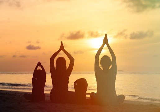 Family Silhouettes Doing Yoga At Sunset