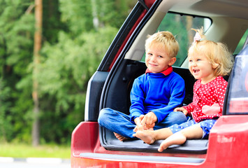 happy little boy and girl travel by car
