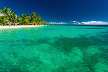 Tropical island in Fiji with beach and water with coral