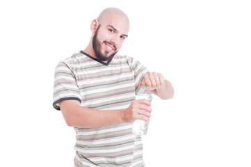 Smiling man opening a bottle of cold water