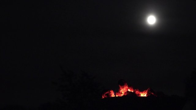 Lagerfeuer und Vollmond bei Nacht