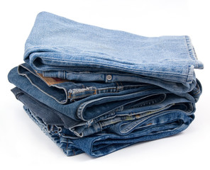 Pack of worn blue jeans isolated on white background