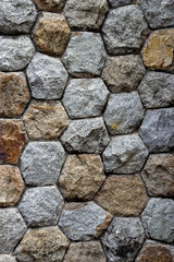 Detail of old stone wall with irregular pentagon and hexagon tiles.