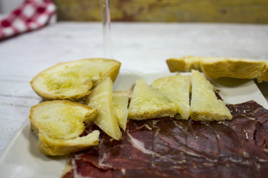 Jamón y queso ibérico con pan sobre tabla de madera