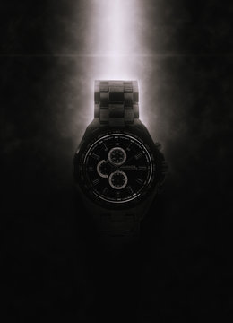 Luxury black wristwatch lit from above
