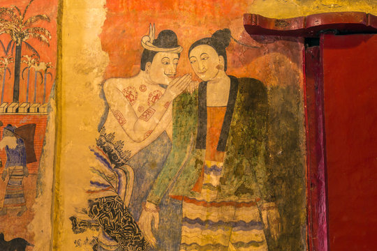 Traditional Thai mural painting on temple wall at Wat Phumin in Nan, Thailand. The famous mural painting of a man whispering to the ear of a woman.