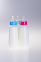 Baby bottle with milk on background