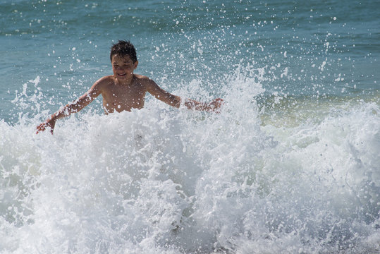 Boy playing with waves in sea