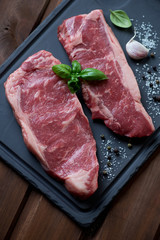 Close-up of raw fresh striploin steaks, high angle view