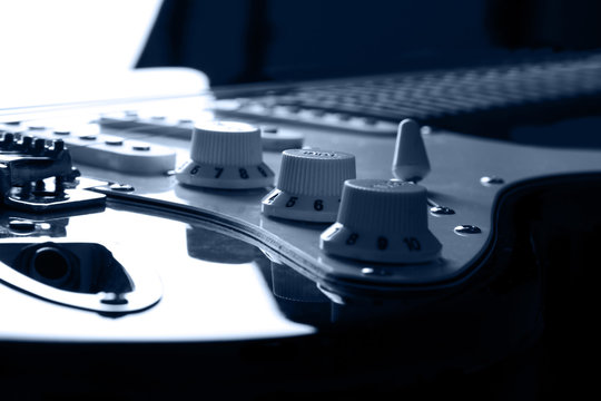 Blue toned electric guitar. Bacground light