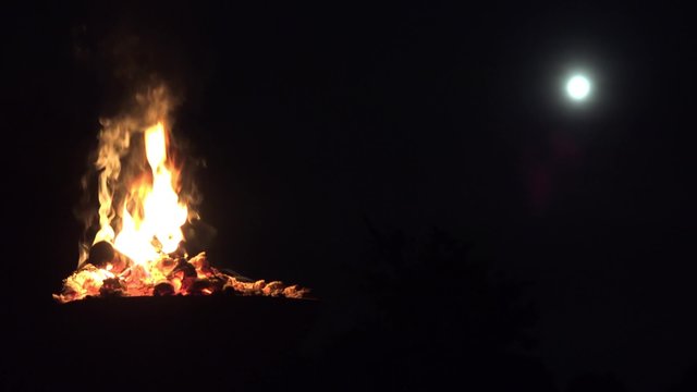 Lagerfeuer und Vollmond bei Nacht
