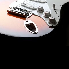Orange electric guitar on black background