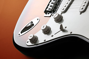 Orange electric guitar on redbackground