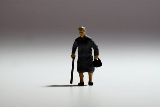 Miniature senior lady walking stick.
Backlit miniature senior lady with walking stick.