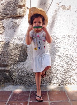 Ni&ntilde;a tocando la arm&oacute;nica con sombrero tejano