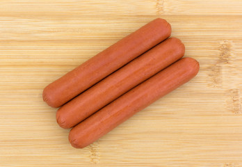 Beef hot dogs on a cutting board.