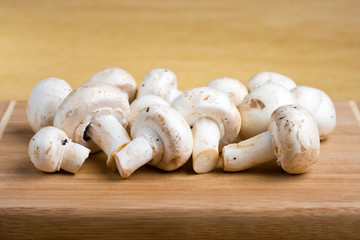 Fototapeta na wymiar White mushrooms on a wooden cutting board
