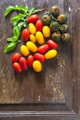 multicolor red and yellow cherry tomatoes on old wooden backgrou