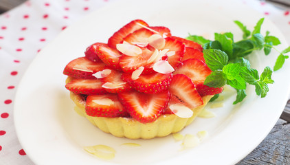 strawberry cake with fresh mint leaves on the wooden surface. Selective focus