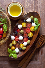 Salad with colored tomatoes, small mozzarella, green olivesand b