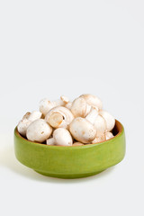 White mushrooms in a green bowl