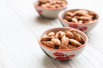 Raw almonds on white wooden board