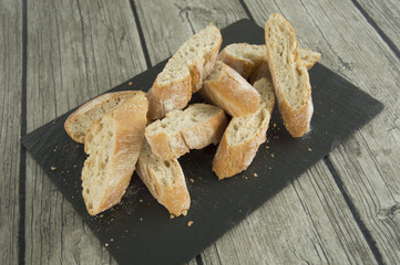Sliced ​​bread, on a black slate plate.
