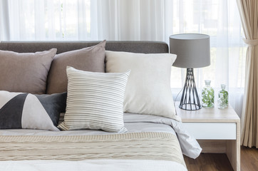 modern style bedroom with pillows on bed and modern grey lamp on