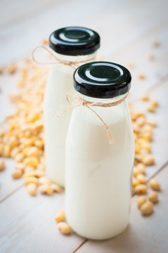 Soy milk [Soya milk ] in  glass bottle with soy pods on white wo