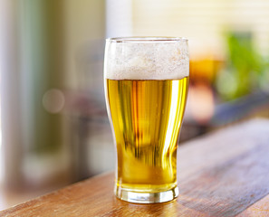 glass of beer on counter top and shot with selective focus