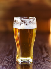 tall glass of beer on wooden background