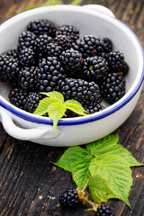 Fresh blackberries in a bowl  on wooden table