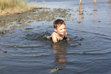Boy lying in the healthy mud