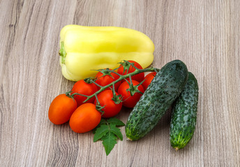 Cucumbers and tomatoes on the branch with yellow pepper