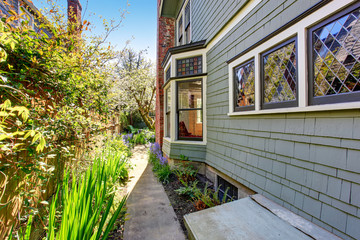 Lovely pathway to back yard of home with flowers.