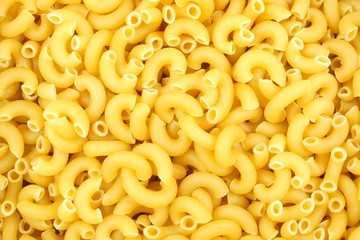 Full background of dry uncooked macaroni pasta