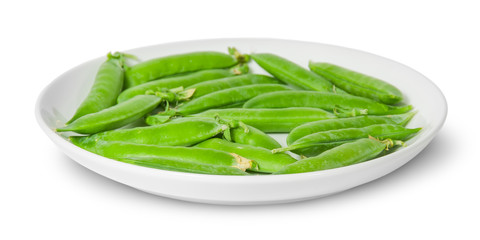 In front several pods of peas on a white plate