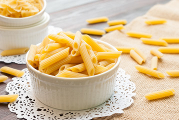 Italian Penne Rigate Macaroni Pasta raw in ramekin bowl, food ba