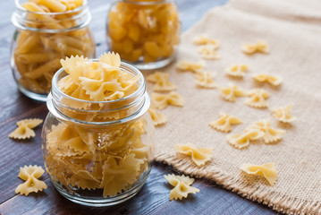 Bow tie pasta in mason jar on wooden board
