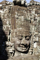 Fototapeta na wymiar Carved stone face at the Bayon 1100's buddhist temple.near Siem Reap,Cambodia