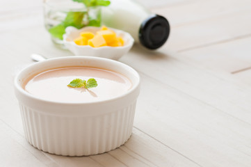 panna cotta, thai tea with mint leaf on white wooden board