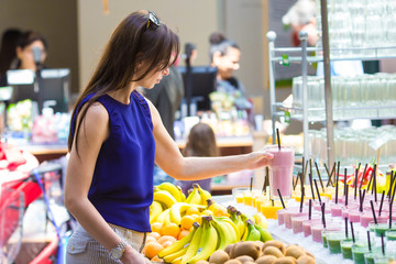 Girl take tasty cocktails in the shop with takeaway