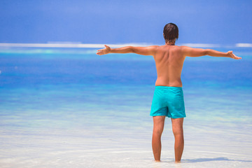 Fototapeta na wymiar Young man enjoying summer vacation on tropical beach