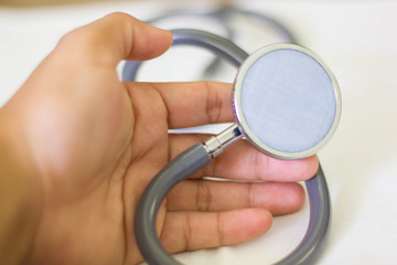 Hand with stethoscope and white background